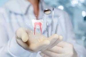 The concept of dental treatment. Doctor shows a tooth in his hand.