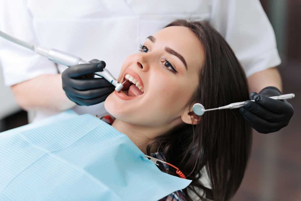 Close-up medical dentist procedure of teeth cleaning.
