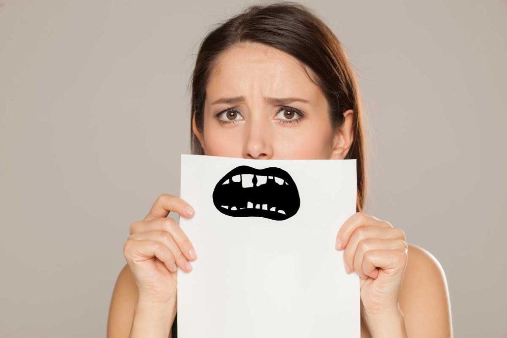 young woman with bad teeth drawn on paper on gray background