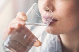 Young woman drinking glass of water