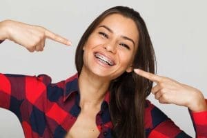 Face of a young woman with braces on her teeth.